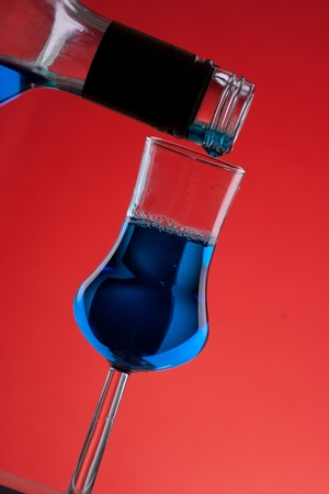 nice blue cocktail glass on red back の写真素材