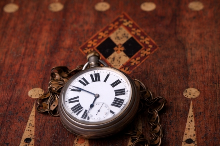 pocket watch on a backgammon tableの写真素材