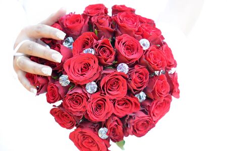 red wedding bouque with hand of brideの写真素材