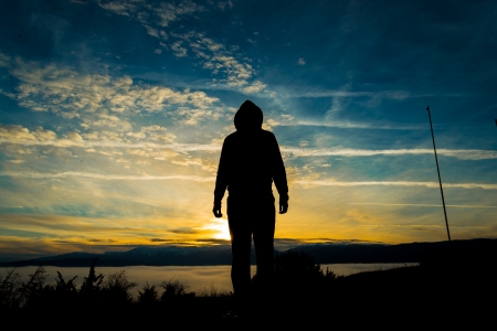Silhouette of man walking on sunset walkingの写真素材