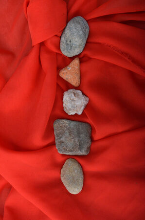 Five stones on red fabricの写真素材
