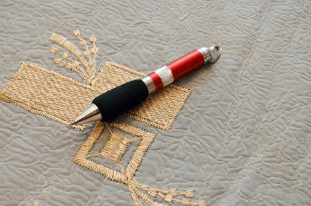 Pen on gold embroideryの写真素材