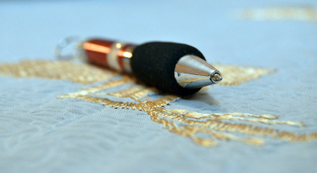Pen on gold embroideryの写真素材