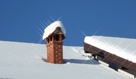 Sun beams on a snow, winter chimneyの写真素材