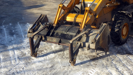 Bulldozer cleaning the road from ice
