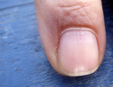 photo of a Man finger on a blue background, macro shot