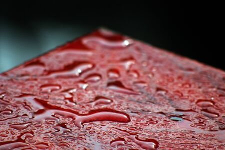 raindrops on a red table surface, photo ofの写真素材