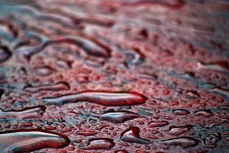 raindrops on a red table surface photo ofの写真素材