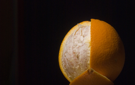 Peeled orange on black backgroundの写真素材