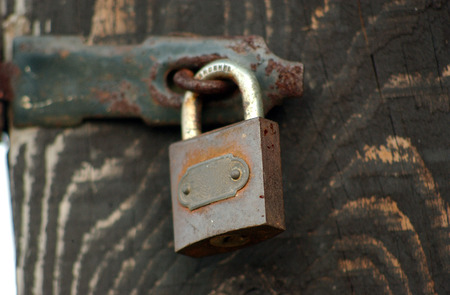 Pic of Old Wooden door locked with rusty padlockの写真素材
