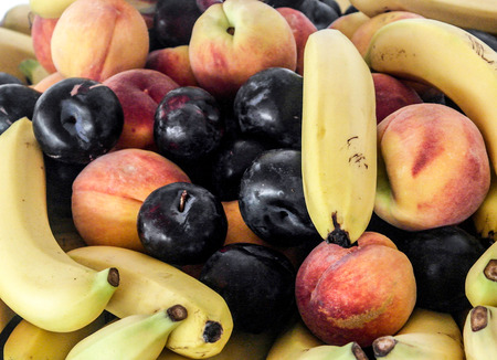 Summer fruits, peaches, bananas, plue plums.の写真素材