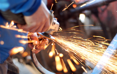 Picture of a hands of a worker  while grinding metal