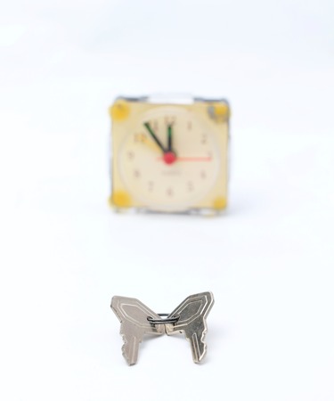 picture of a keys in front of vintage alarm clockの写真素材