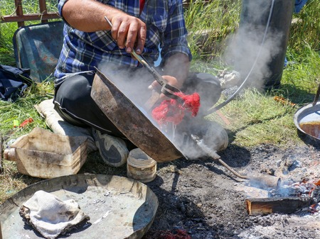 RESEN, MACEDONIA. MAY 18 , 2016- Young  traveling artisan retinning old copper dish in village of Carev Dvor,Resen,  Macedoniaのeditorial素材
