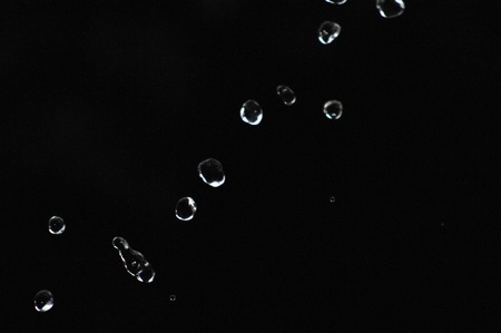 picture of a Water drops levitating in the air in dark. Splashing water fly in the air. Part of the...