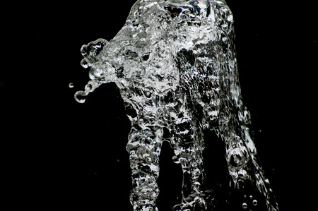 picture of a Water drops levitating in the air in dark. Splashing water fly in the air. Part of the drops is in focus, part - out of the focus.の写真素材