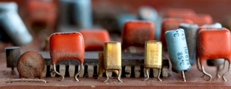 Part of old vintage printed circuit board with electronic components.