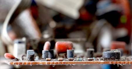 Part of old vintage printed circuit board with electronic components.