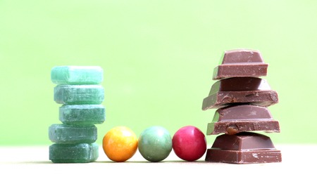 picture of a Green mints candy ,chocolate pieces and bubble gum on green background.の写真素材