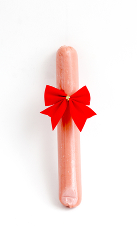 red ribbon bow-tie on a sausage on a white backgroundの写真素材