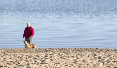 man and dog on a beach of lake prespa in macedonia,picture ofの写真素材