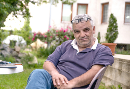 Relaxed senior sitting on a chair in backyardの写真素材