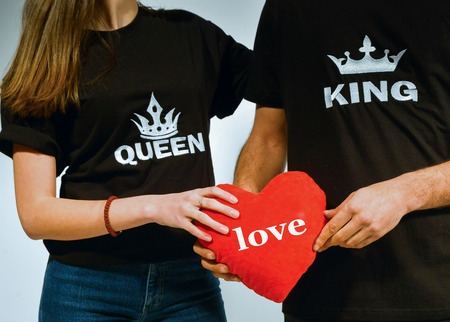 image of a Happy couple holding red heart pillowの写真素材