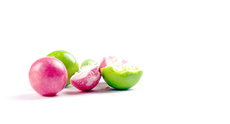 pink and green gumballs on a white background.の写真素材