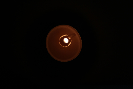 Burning candle on a black backgroundの写真素材