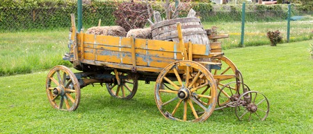 yellow wooden wagon with painted wheels.の写真素材