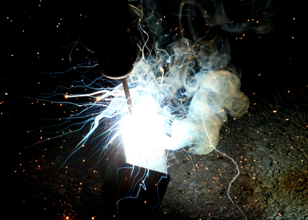 Sparks and jets of smoke when welding of steel structures,image of a