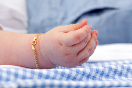 Baby hand with gold braceletの写真素材