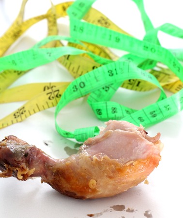 Grilled chicken leg and tapemeasure on white background.shallow dofの写真素材
