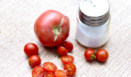 salt shaker, fresh cherry tomato and tomato on a table,image of aの写真素材