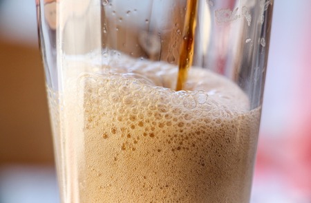 pouring dark beer in a glass