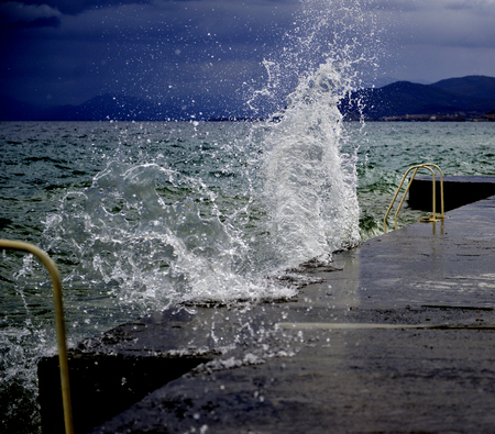 The waves breaking on a concrete embankment on lake ohrid, macedonia,image of aの写真素材
