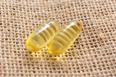 Cod liver oil omega 3 gel capsules on bag background