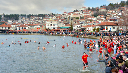 OHRID, MACEDONIA - JANUARY 19, 2017: Men swim in the cold water to retrieve the cross at the Epiphany , in Ohrid, Macedoniaのeditorial素材