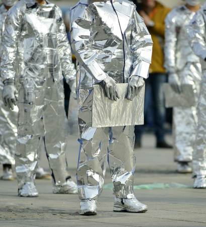 unrecognizable man wrapped with aluminium foil, holding bookの写真素材