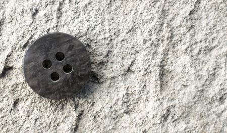 old used sewing button on a cement backgroundの写真素材