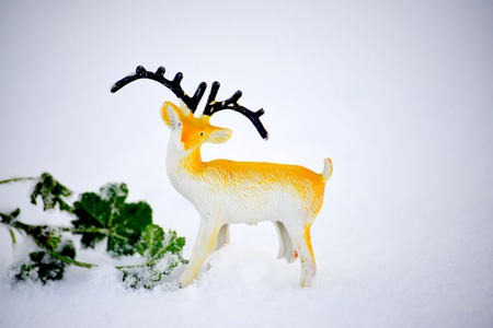 deer figurine toy on a snow, winter theme, imageの写真素材