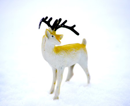 deer figurine toy on a snow, winter theme, imageの写真素材