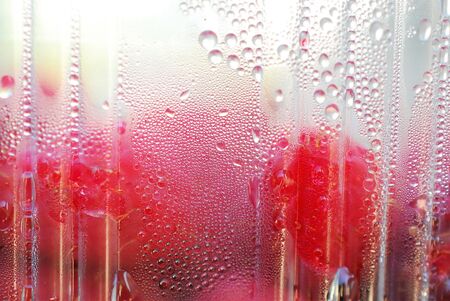 dew drops on a plastic container with raspberries imageの写真素材
