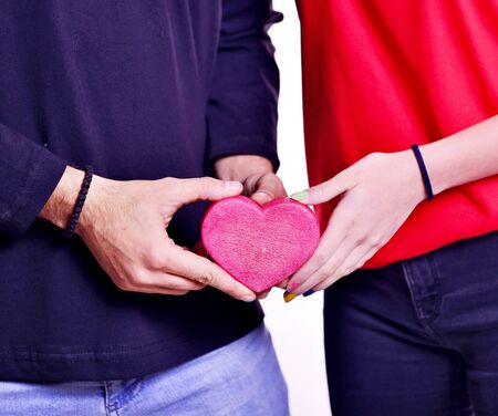 male and female handing piece of heart shaped object.の写真素材