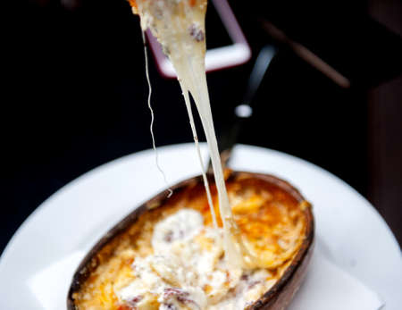 Oven baked cheese in a ceramic baking dish.image