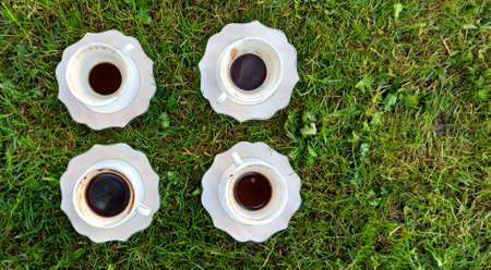 The cup of coffee on a morning grass imageの写真素材
