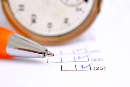 orange pen on a sheet of white paper with printed financial numerical data table with columns with...