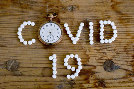 Treatment concept COVID-19. The name of the virus is written with white pills imageの写真素材