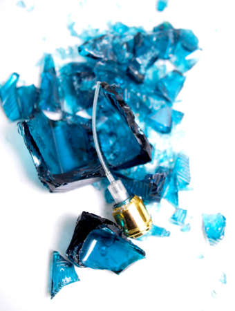 Broken perfume bottle on white background