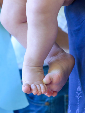 mother holding cute feets of a baby.